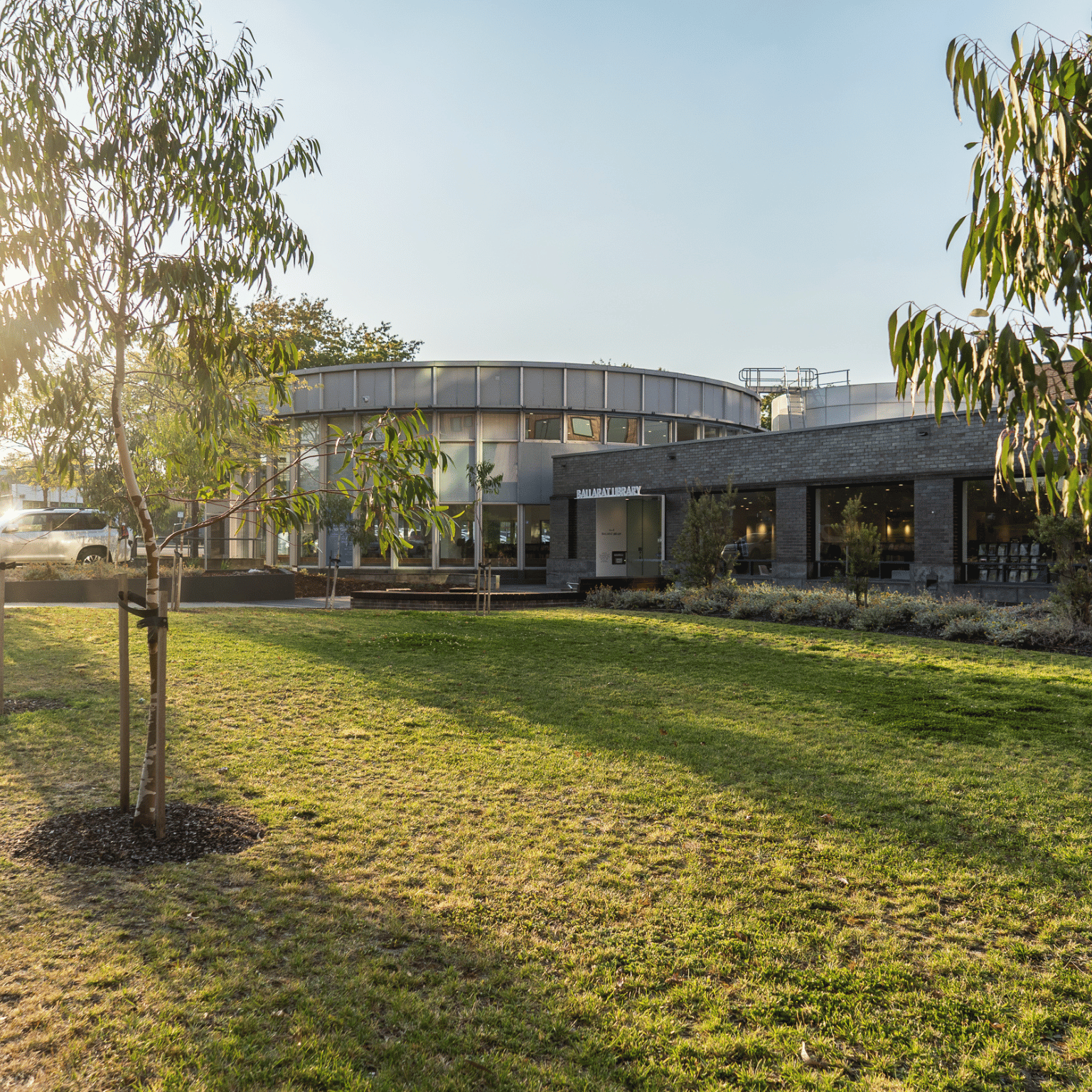 An external photo of the Ballarat Library, looking past a grassed area with a small native tree.