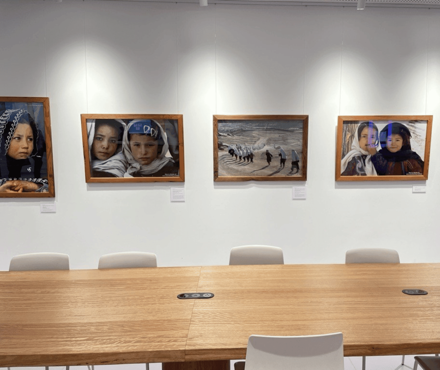 Photo of a section of the exhibition, featuring photos of young girls in the desert-like Afghanistan landscape.