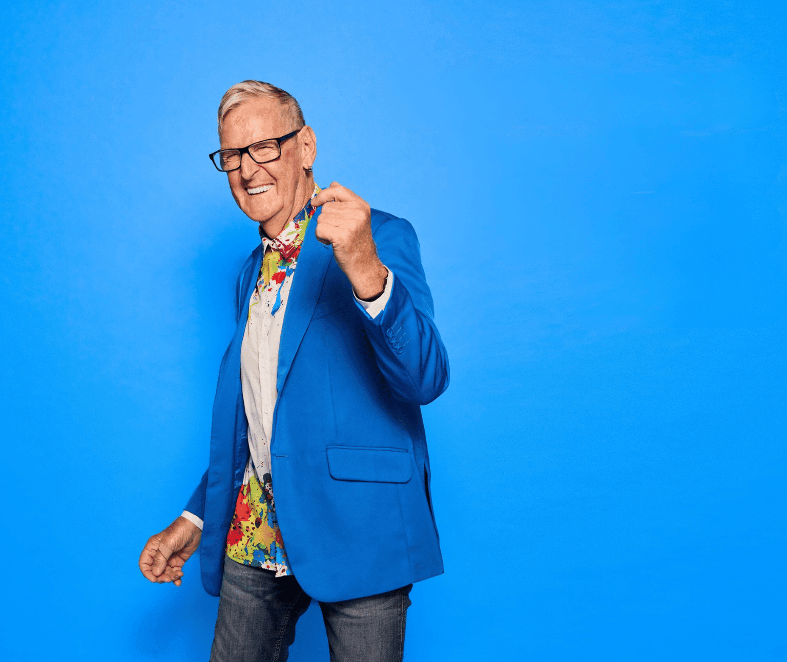 Photo of a grinning older man in a bright blue blazer.