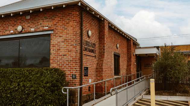 Photo of back entrance of Sebastopol Library, featuring beautiful brickwork and an accessibility ramp.