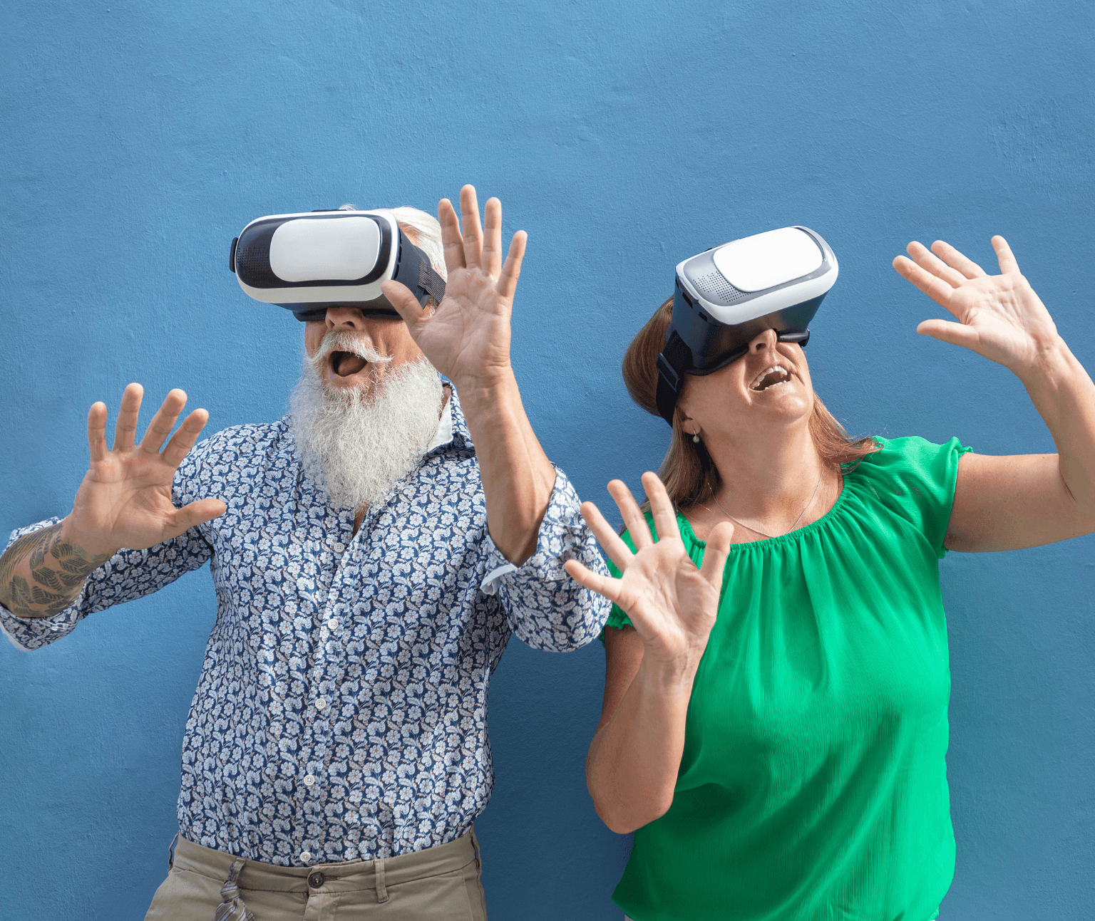 Photo of two older people wearing Virtual Reality headsets.