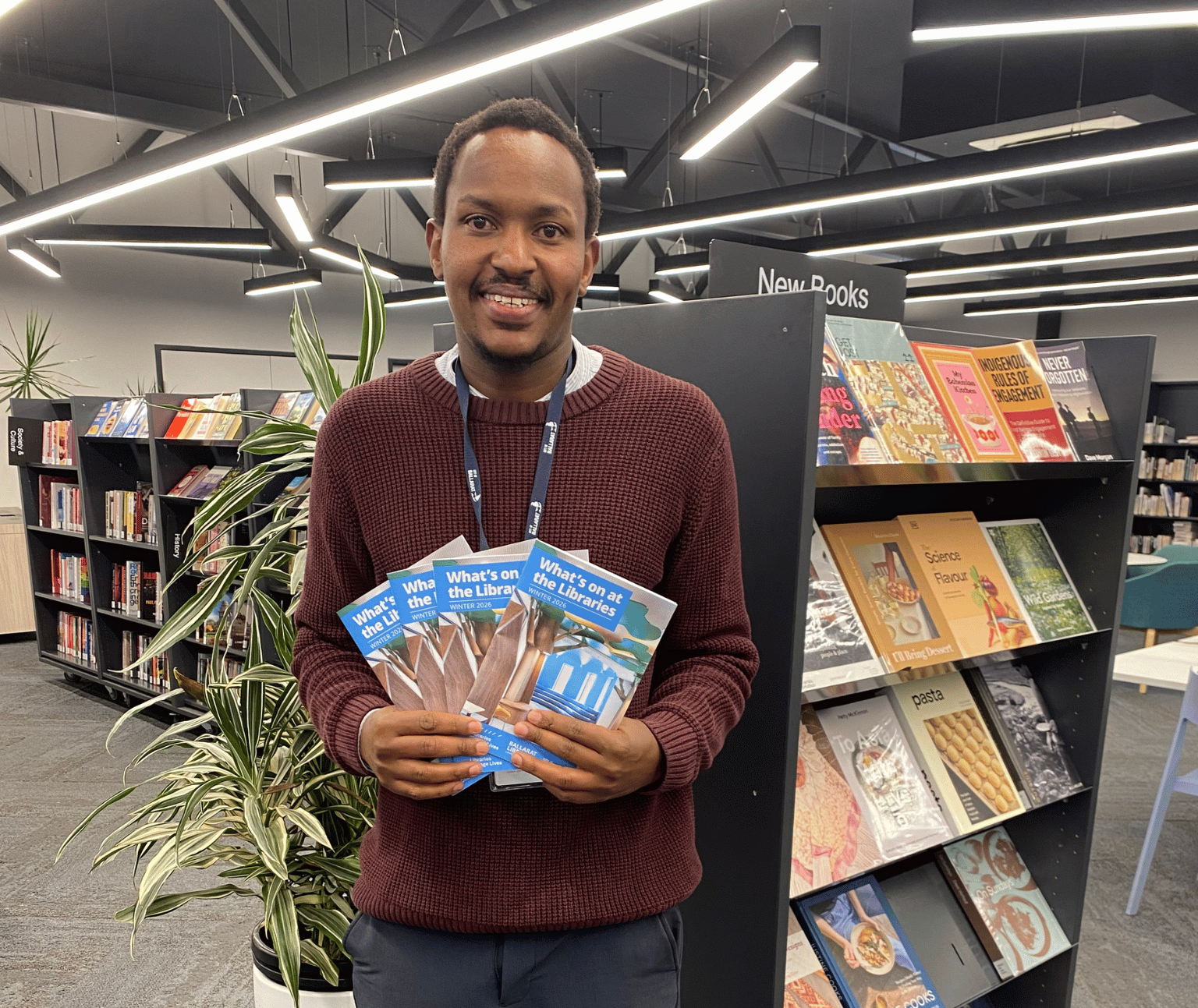 Photo of library staff member holding copies of the Winter What's On brochure.